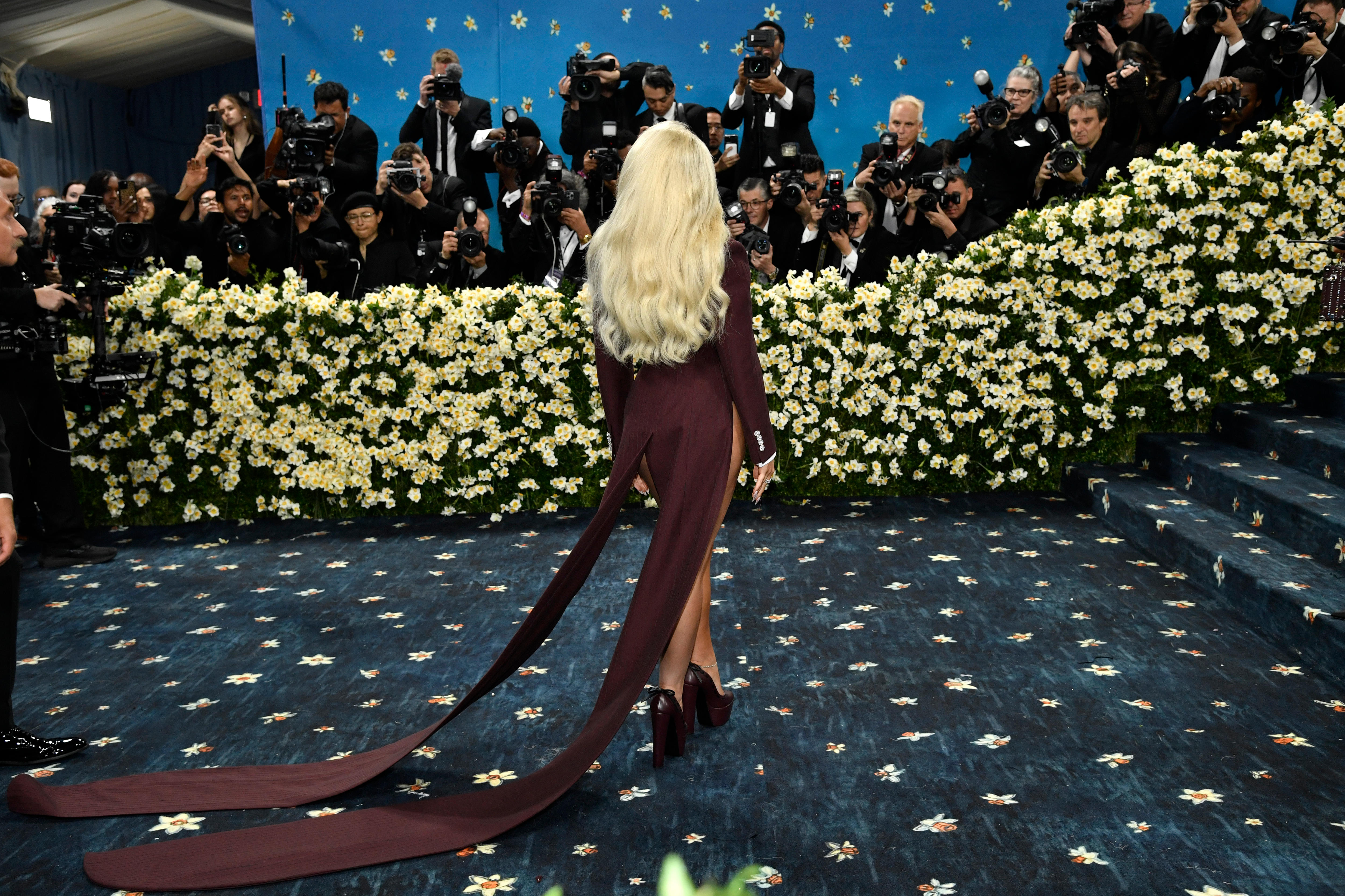 Sabrina Carpenter wearing a maroon leotard with long coat tails