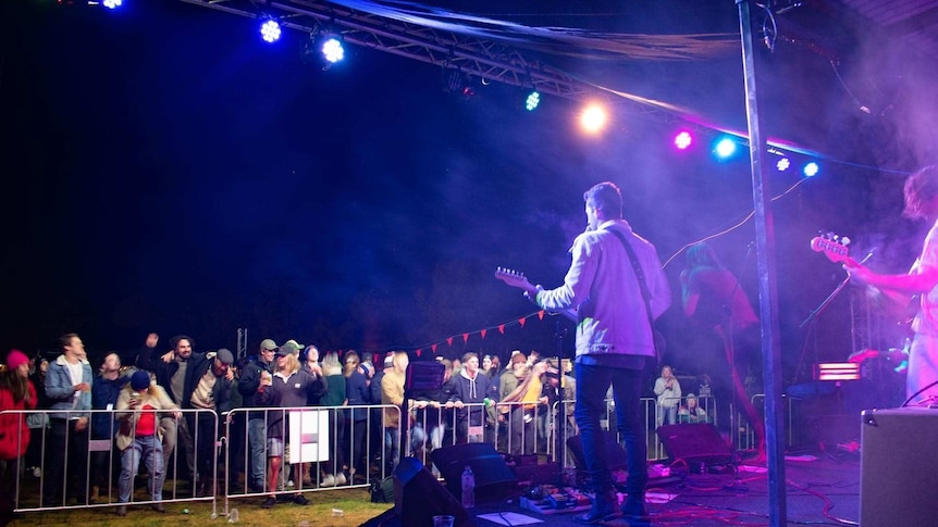 A band plays to a crowd of fans.