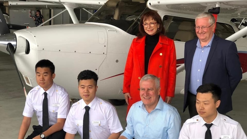 Anne Webster, Simon Clemence and Michael McCormack smiling in a photo with Chinese pilots.