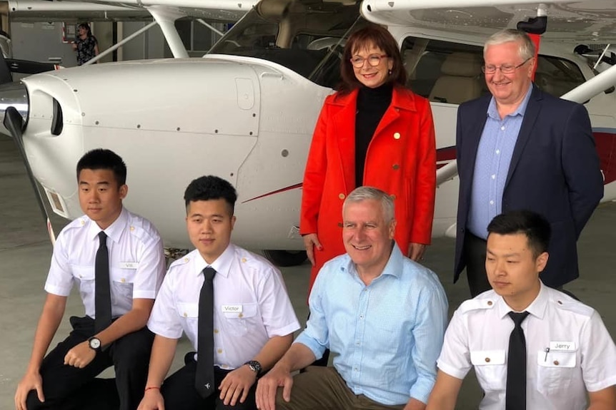 Anne Webster, Simon Clemence and Michael McCormack smiling in a photo with Chinese pilots.