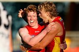 two Gold Coast Suns players hug in celebration
