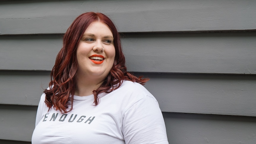 Sarah Bryan, a young woman with red hair, smiles at the camera.