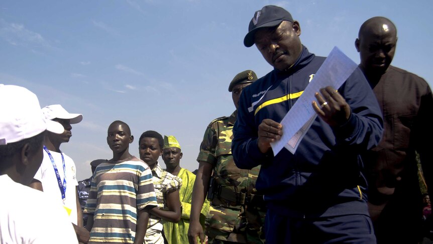 Pierre Nkurunziza is registered by an election official before casting his ballot