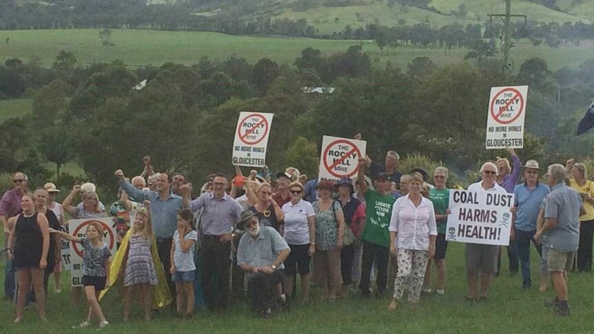 Gloucester residents standing in the Valley holding placards protesting the proposed Rocky Hill coal mine project