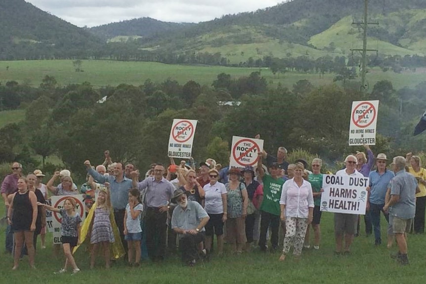 Gloucester residents standing in the Valley holding placards protesting the proposed Rocky Hill coal mine project.