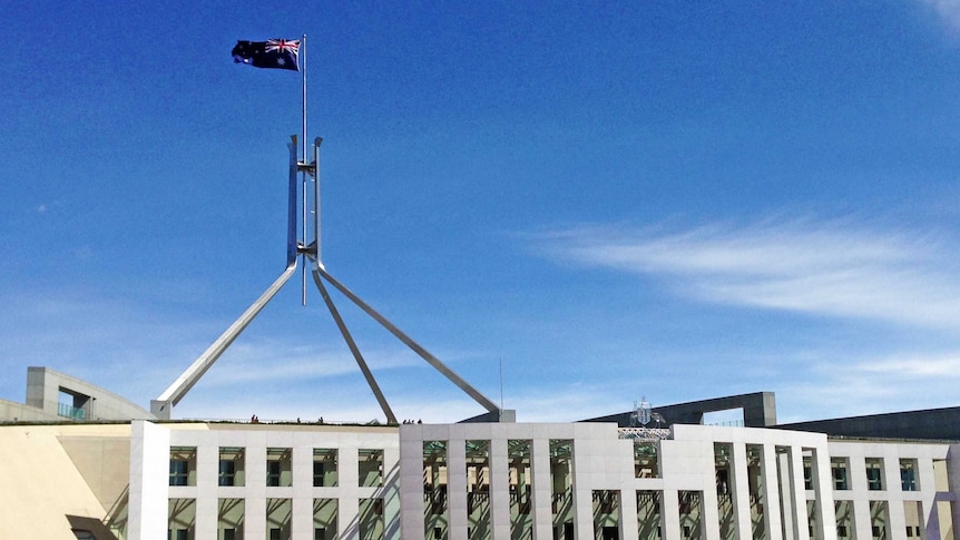 People walk towards Parliament House in Canberra.