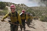 Still colour image from 2017 film Only The Brave of Josh Brolin and a crew of firefighters trekking up scrubland.