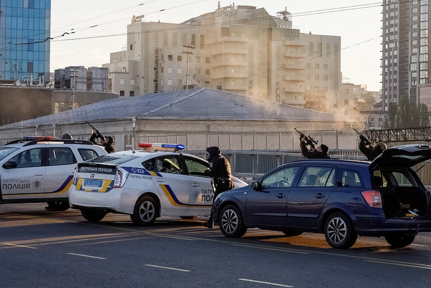 Police officers shoot at a Russian drone in Kyiv.