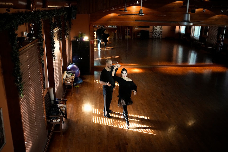 Man and woman rehearse a ballroom dancing routine in Moscow.