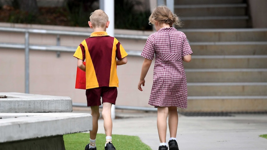 Two primary school children walk side by side