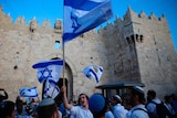 Israelis wave national flags outside the Old City's Damascus Gate.