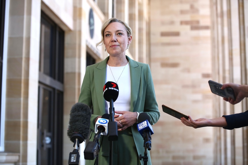 A blonde woman speaks at a press conference. 