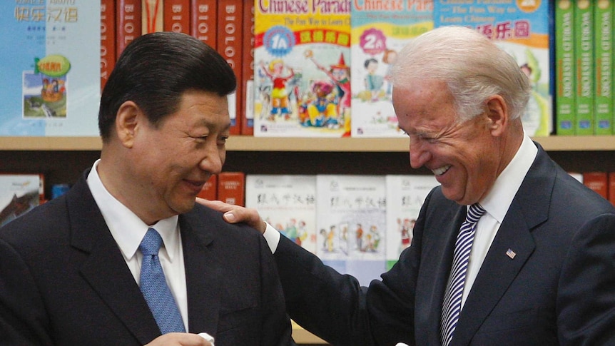 Joe Biden smiling with his hand on Xi Jinping's shoulder