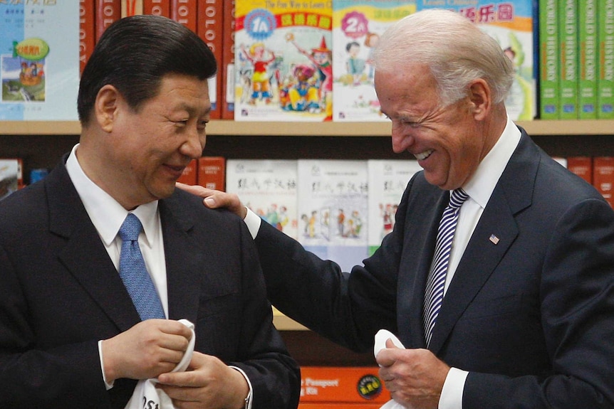 Joe Biden souriant avec sa main sur l'épaule de Xi Jinping
