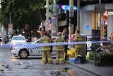 Emergency services staff at Bourke Street following a fatal stabbing.