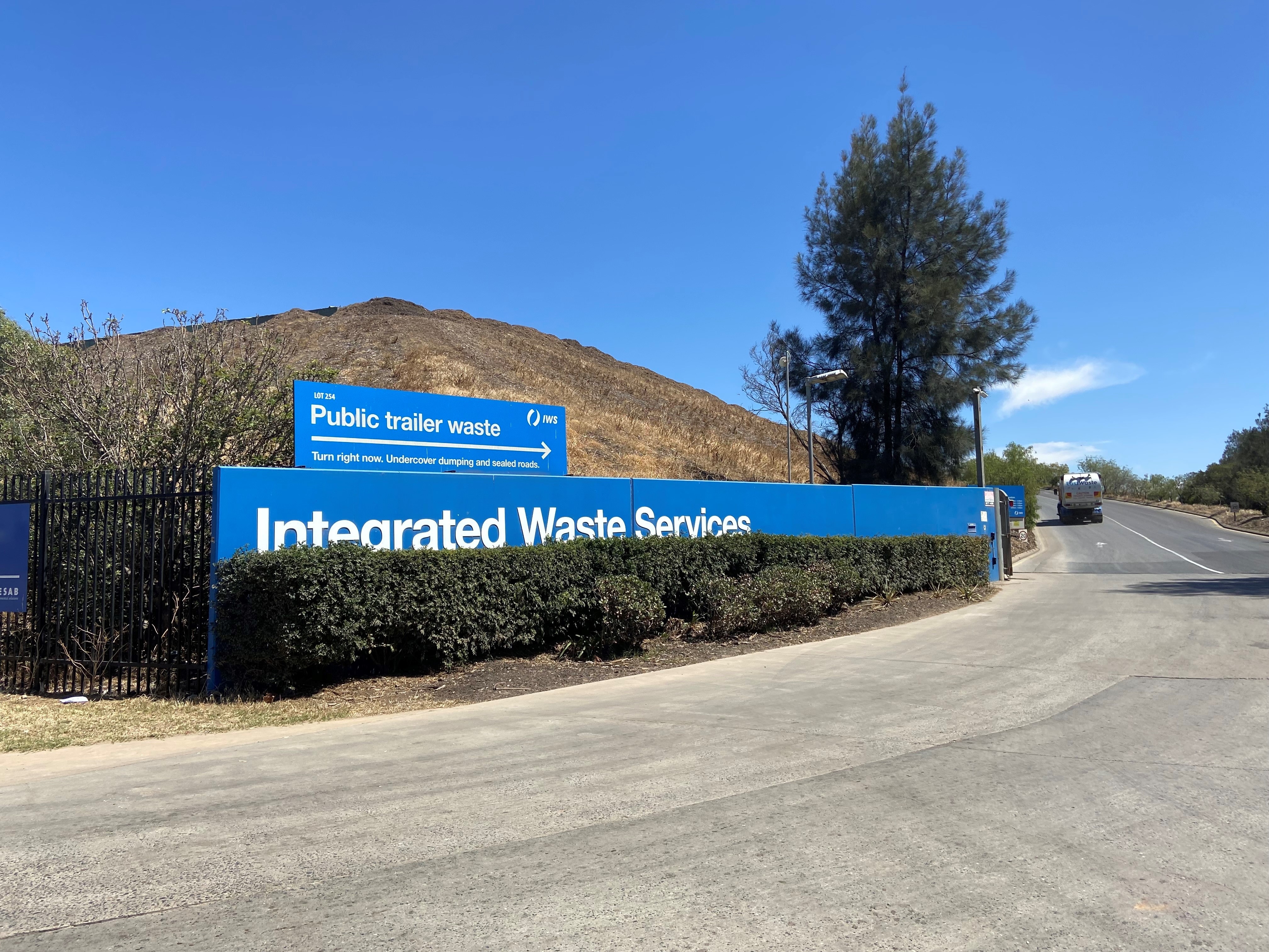 A sign of a waste facility with an arrow pointing towards public trailer waste.
