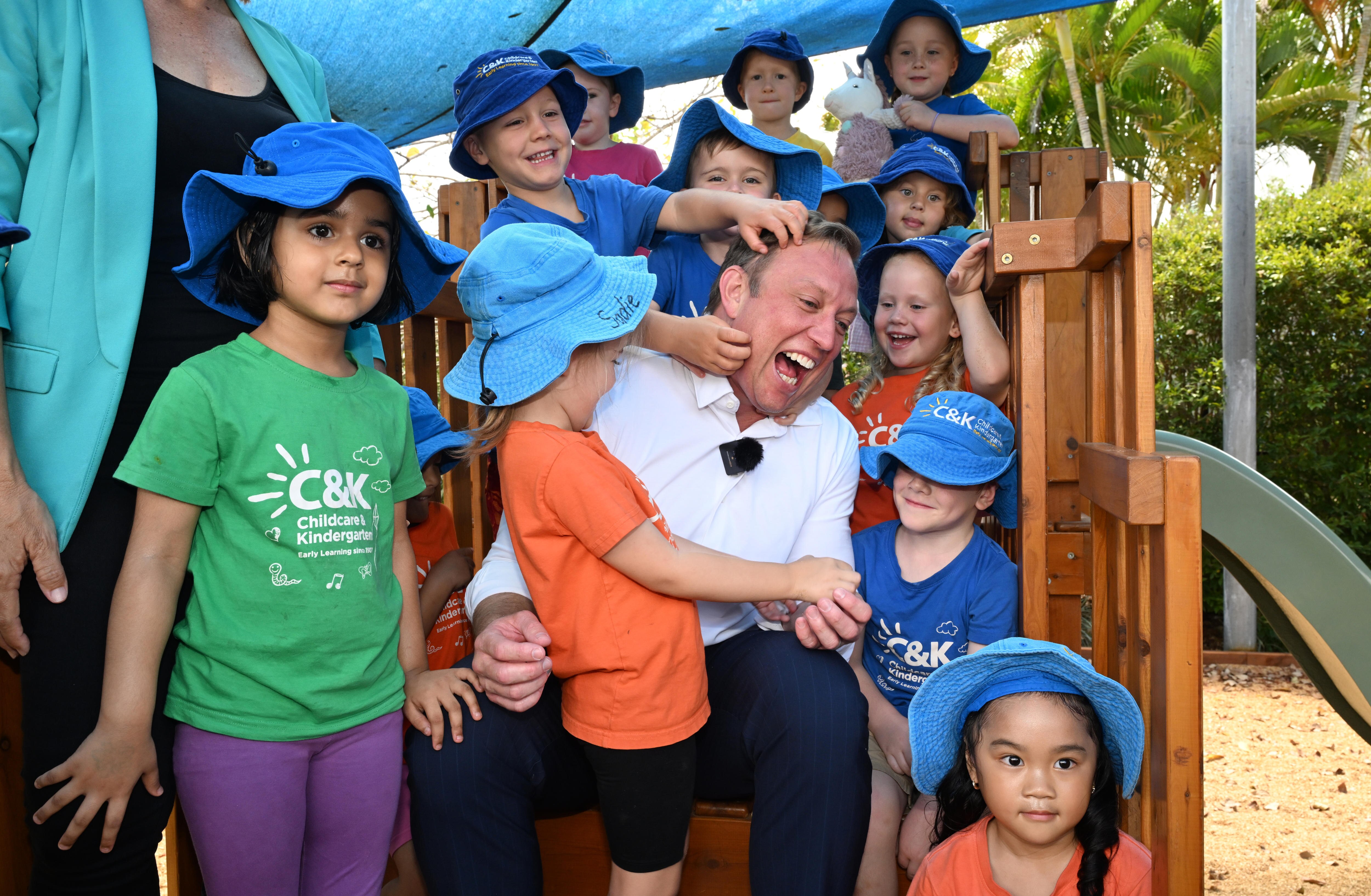 Steven Miles surrounded by children, everyone laughing. 