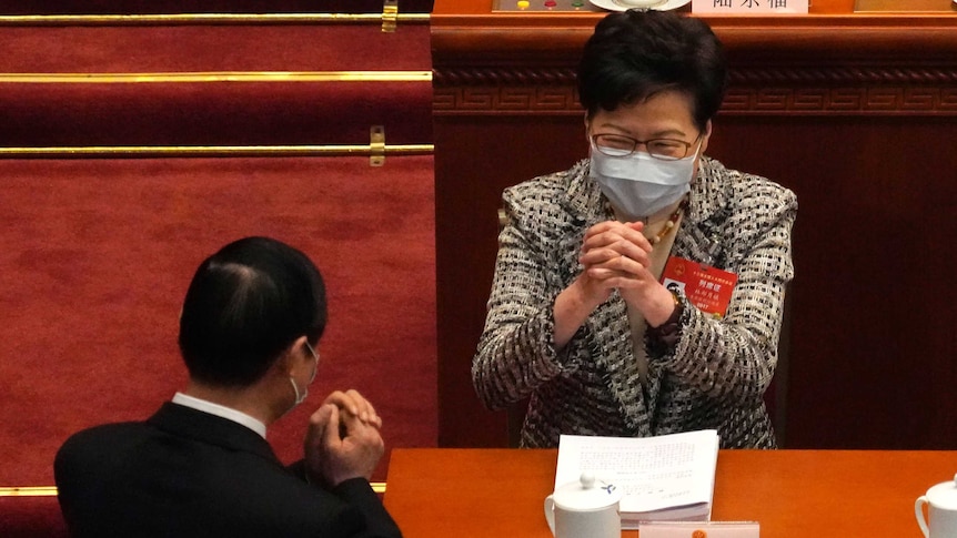 Hong Kong's leader greeting a party official at China's National People's Congress in Beijing