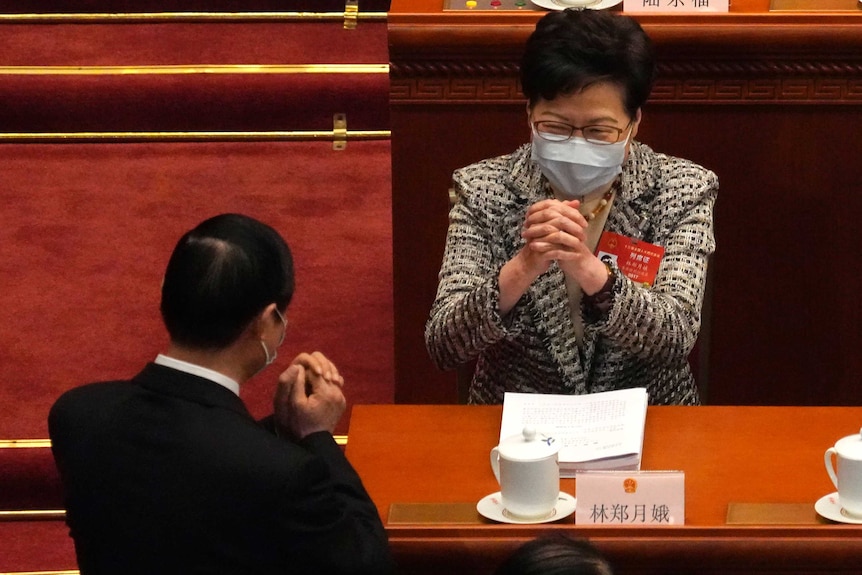 Hong Kong Chief Executive Carrie Lam, right, exchanges greetings with a fellow delegate.