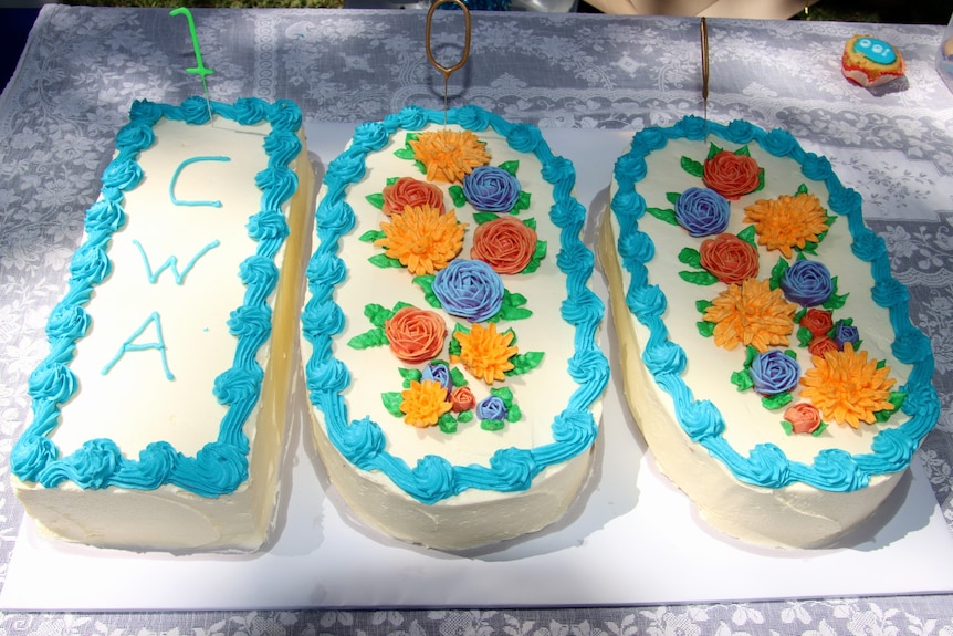 Three decorated cakes spelling "100"