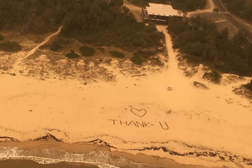 Thank you and love heart written in sand