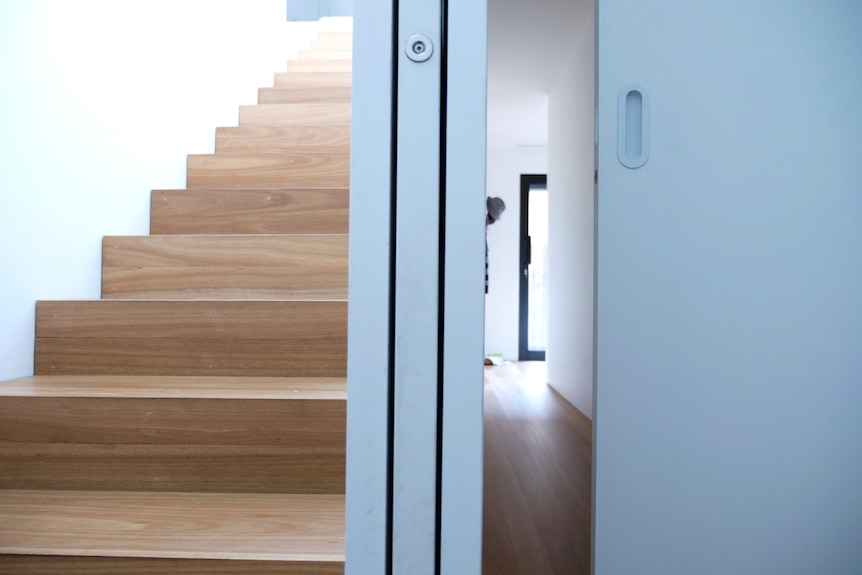A set of stairs is on the left, a sliding door is retracted in the middle, another sliding door is half closed to the right