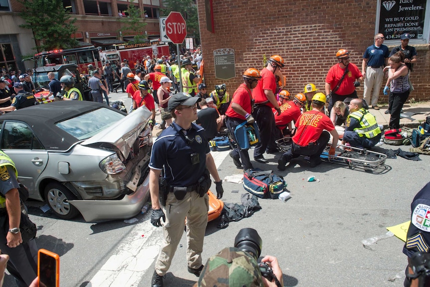 Emergency crews treat a woman after a car ran into a crowd of protesters in Charlottesville.