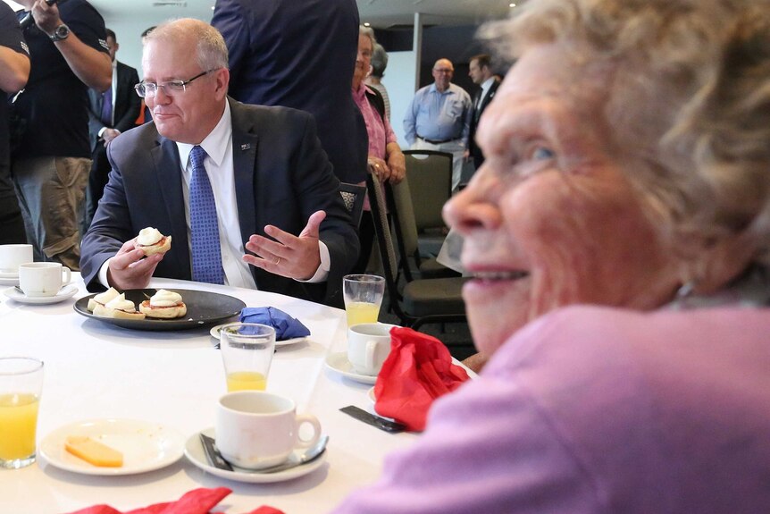 Scott Morrison eats a scone with jam and cream