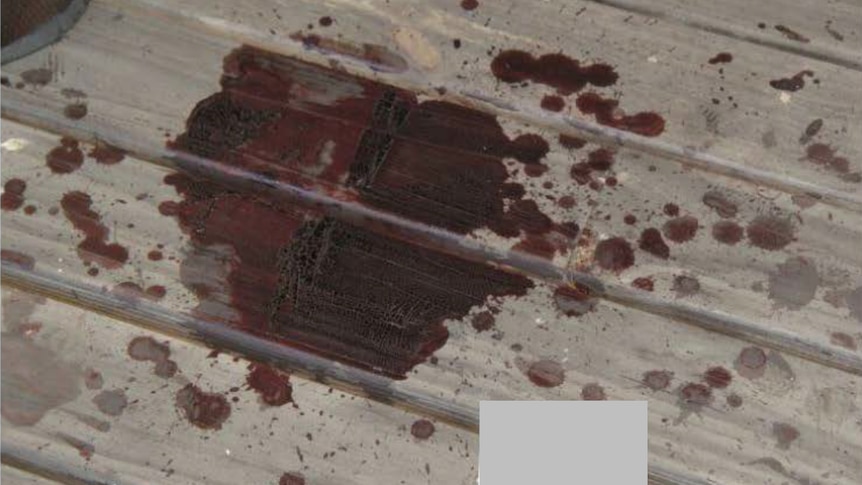 A dried splatter of blood on a sheet of tin. 