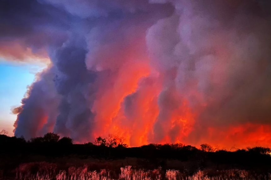 A dark smokey purple horizon with a bright fire burning below