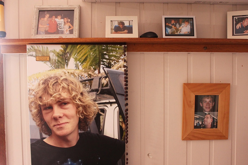 Photos of a young man on a wall and along a shelf in a family home