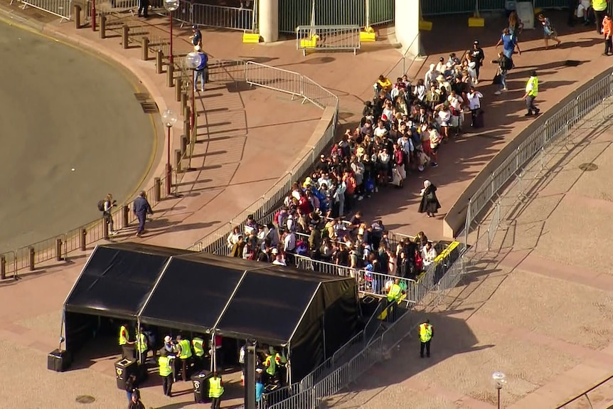 people lining up outside the opera house in sydney