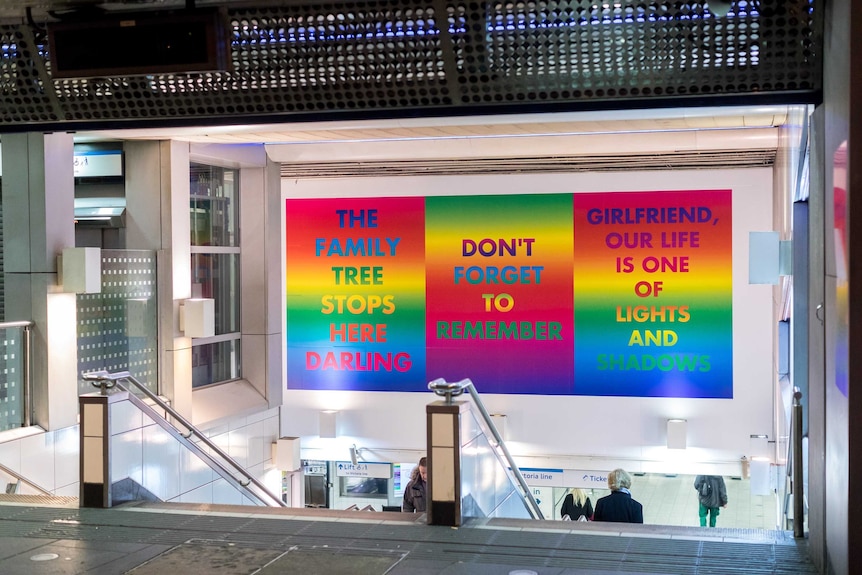 Brightly coloured signs above the stairwell entrance to Brixton train station in London.