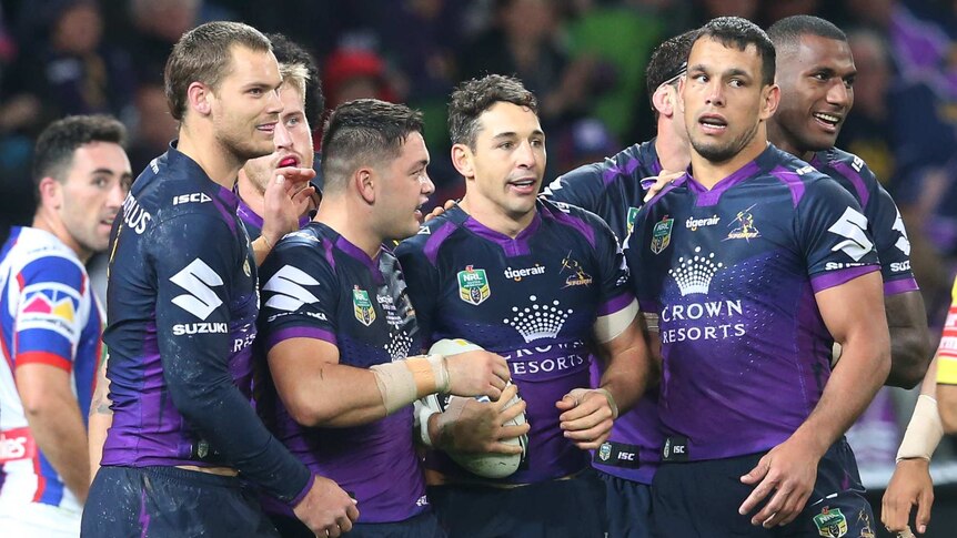 Melbourne Storm players get around try-scorer Billy Slater.