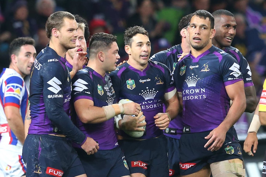 Melbourne Storm players get around try-scorer Billy Slater.