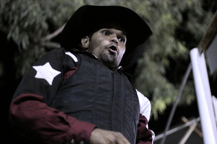 A bull rider taking a deep breath just before his chute opens.