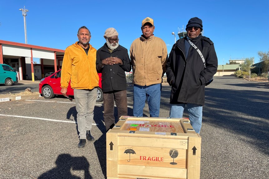 Warlpiri men with their cultural heritage material at the Alice Springs airport.