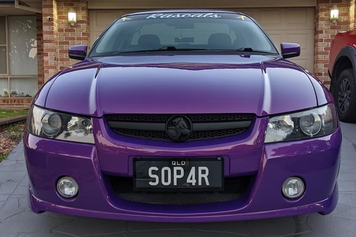 A purple Holden ute in the driveway of a home. 
