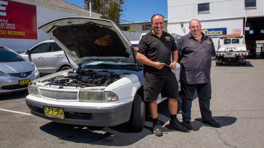 Mechanic Mick Marendy and auto electrician Stephen Cave stand next to white sedan