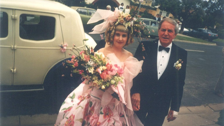 Bride Jenny Rasmussen resplendent in a pink outlandish 1980s wedding dress accompanied by her father Norm.