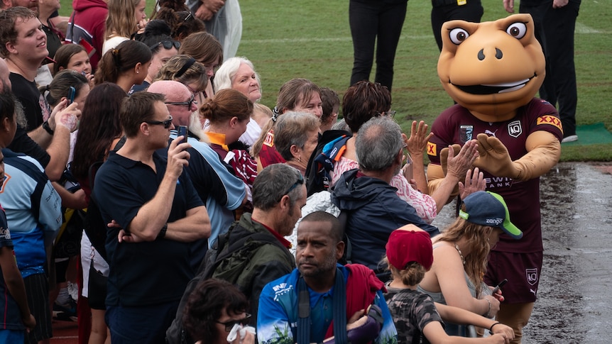 mascot in cane toad suit high fives crowd members 