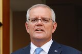 Scott Morrison wearing a light blue tie mid-sentence pointing with his left hand