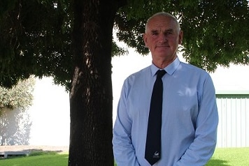 man standing under a tree in a suit