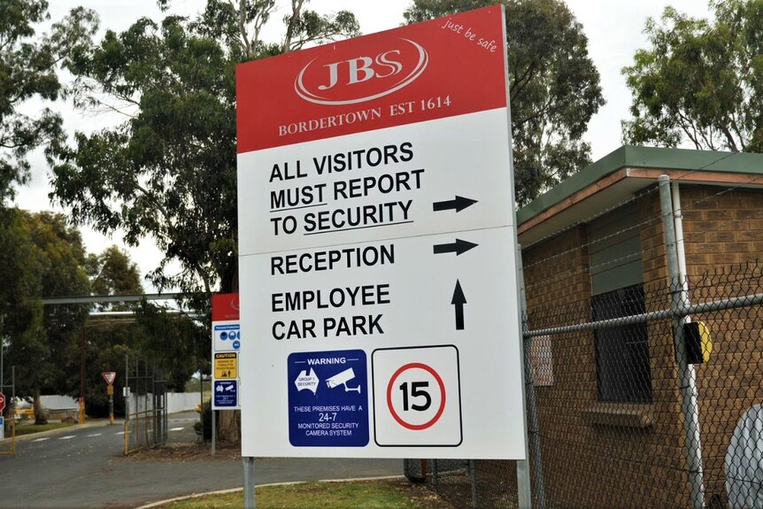 A large sign at the front of an abattoir directing people where to park, where reception is and to report to security.