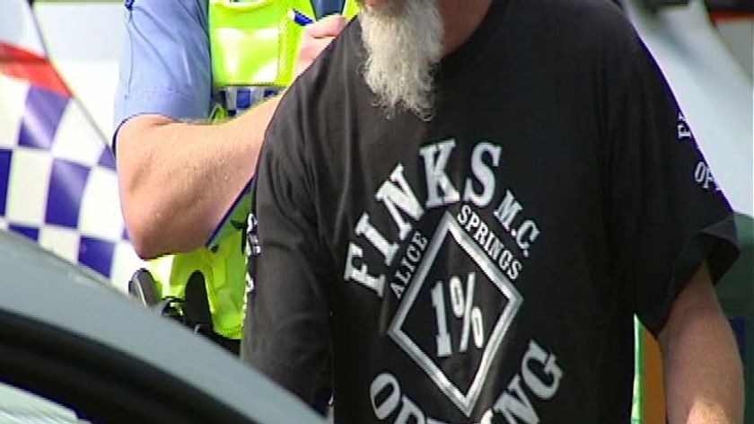 Police prepare to search the baggage of a Finks bikie.