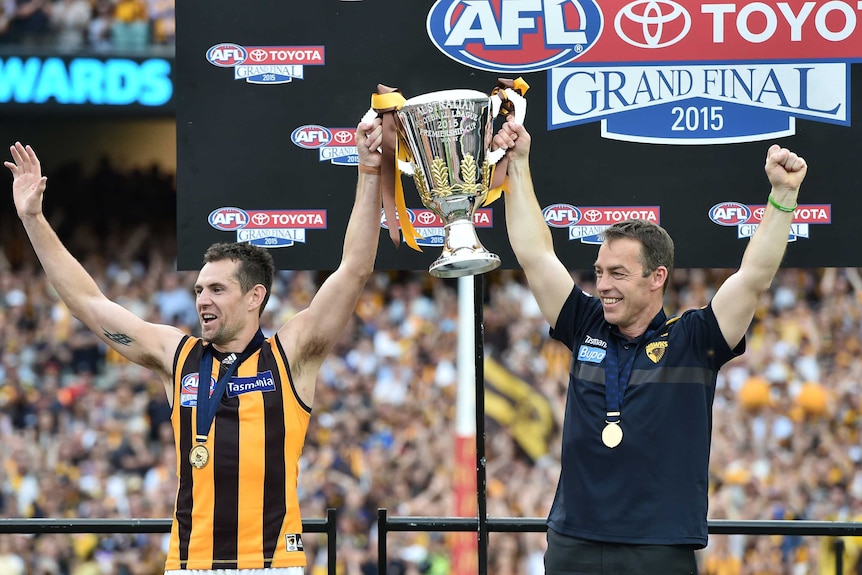 Luke Hodge and Alastair Clarkson lift the AFL premiership trophy