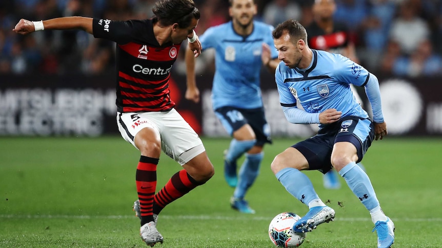 Adam Le Fondre, in blue, attempts to go past Daniel Georgievski by turning the ball with the outside of his right boot