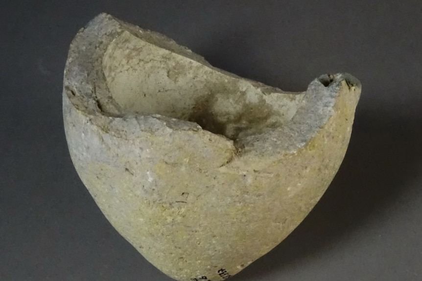 A small sphero-conical clay vessel showing signs of damage