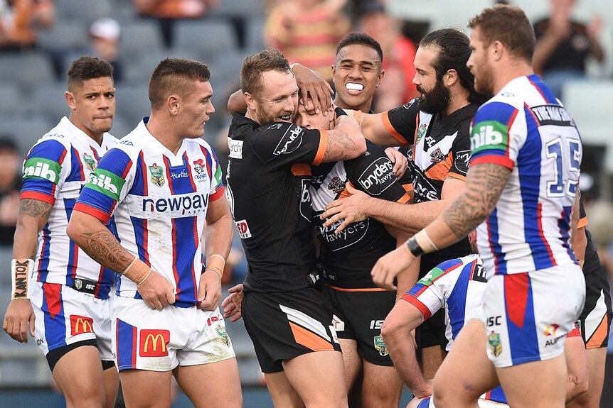 Wests Tigers celebrate Mitchell Moses' try against the Knights