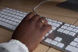 Good generic of an African Australian woman's hand on a computer keyboard
